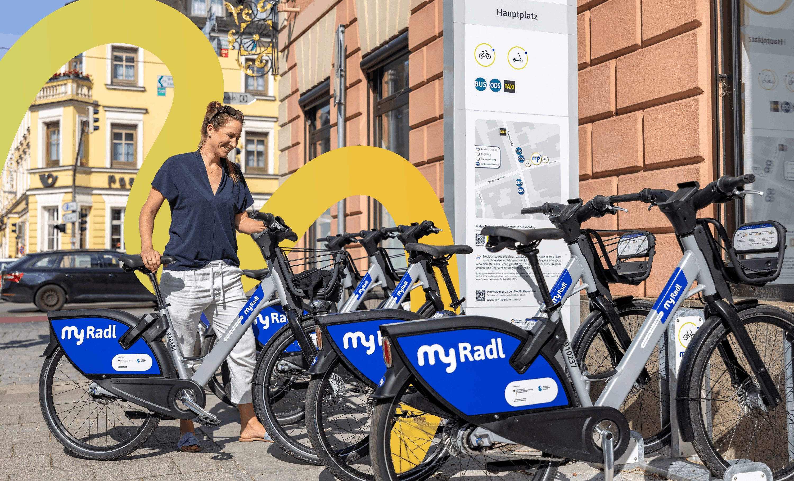 Frau leiht ein Fahrrad an einer Leihradstation aus.