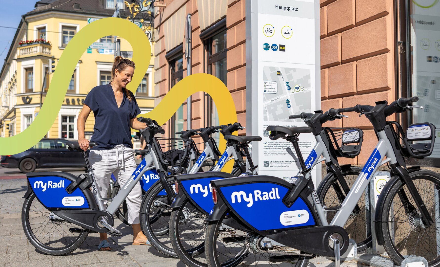 Frau leiht ein Fahrrad an einer Leihradstation aus.